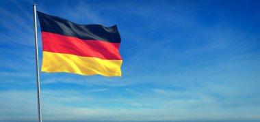 Almanya 'nın ulusal bayrağı açık mavi gökyüzünün önünde rüzgarda dalgalanıyor.