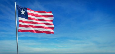 Liberya 'nın ulusal bayrağı açık mavi gökyüzünün önünde rüzgarda dalgalanıyor.