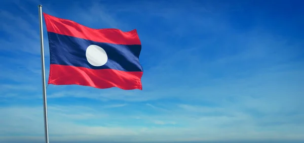老挝的国旗在清澈的蓝天前迎风飘扬 — 图库照片