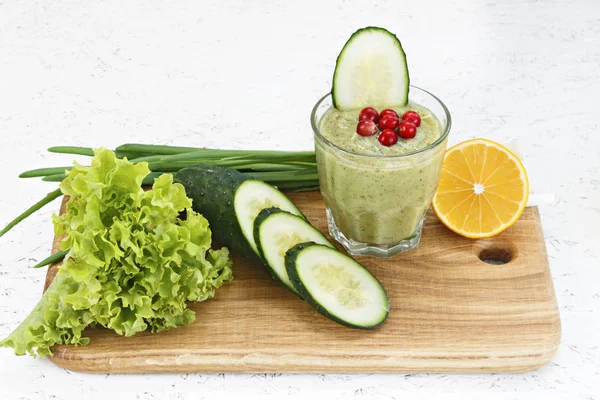 Arıtma detoksifikasyon, bir yeşil sebze kokteyl maddeler üzerinden kavramı. Doğal, organik sağlıklı meyve suları için bir diyet kilo kaybı ya da oruç için bir şişe. Salatalık, üzerinde beyaz wo izole limon ve marul, kızılcık, yeşil soğan