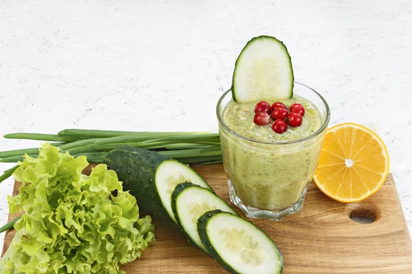 Arıtma detoksifikasyon, bir yeşil sebze kokteyl maddeler üzerinden kavramı. Doğal, organik sağlıklı meyve suları için bir diyet kilo kaybı ya da oruç için bir şişe. Salatalık, üzerinde beyaz wo izole limon ve marul, kızılcık, yeşil soğan