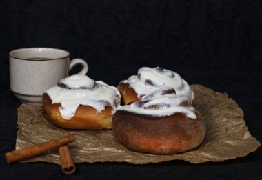 Tarçın ve kahve parşömen kağıt ve karanlık bir arka plan ile buns.