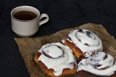 Tarçın ve kahve parşömen kağıt ve karanlık bir arka plan ile buns.