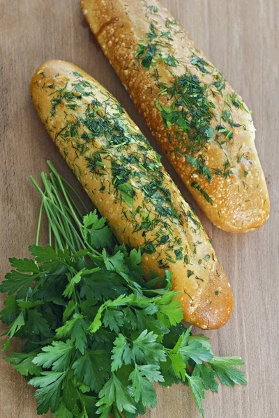 Baget ile sarımsak ve yeşillik bir ahşap tahta üzerinde. Yukarıdan görüntülemek.