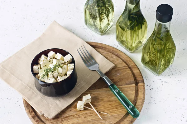 Ahşap oyun tahtası yeşillikleri ile beyaz bir arka plan üzerinde beyaz peynir.