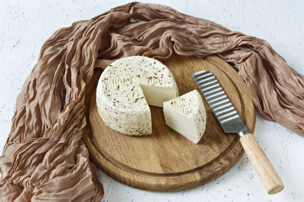 White cheese on a wooden board on a white background with greens. — Stock Image White Cheese Wooden Board White Background Greens Stock Picture