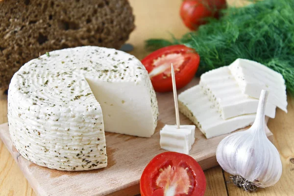 White cheese, bread, tomatoes and garlic on a wooden background. — Stock Image White Cheese Bread Tomatoes Garlic Wooden Background Royalty Free Stock Photos