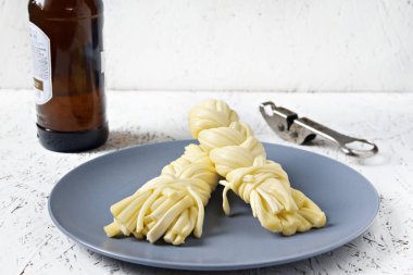 Bir plaka üzerinde bir gri plaka ve bira peynir. Sulguni peynir.