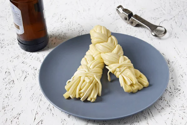 Bir plaka üzerinde bir gri plaka ve bira peynir. Sulguni peynir.