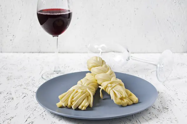 Bir tabak ve şarap beyaz zemin üzerine peynir. Sulguni peynir.