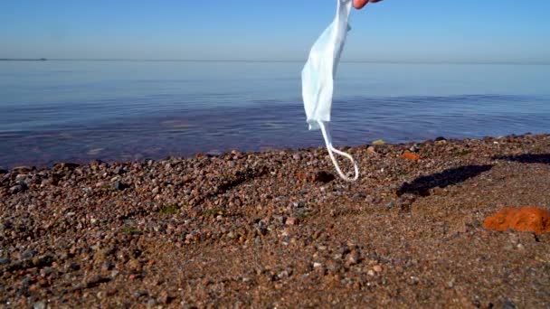 Медична Маска Руці Розвивається Під Вітром Тлі Моря Чоловік Тримає — стокове відео