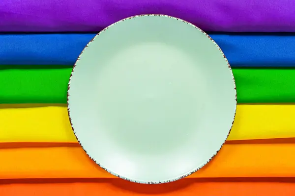 Placa branca no fundo de um arco-íris símbolo LGBT fechar - para cima para o design. Prato de almoço em um fundo de arco-íris . — Fotografia de Stock