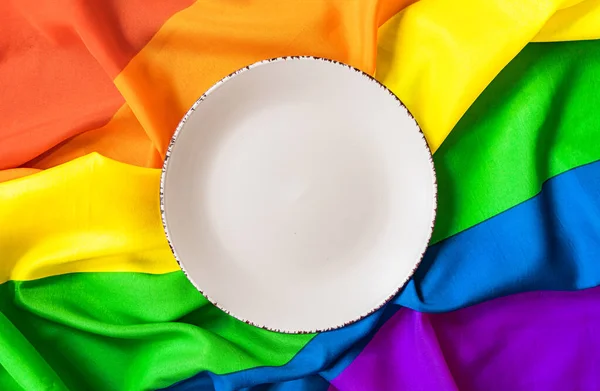 Gökkuşağı LGBT sembolünün arka planında beyaz plaka var. Tasarım için yakın plan. Gökkuşağı arka planında öğle yemeği.