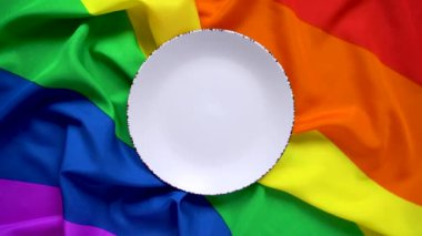  Gökkuşağı bayrağında beyaz plaka. Tasarım için altı renkli LGBT bayrağı. LGBT topluluğunun yemek masasının tasarımı. Öğle yemeği için gökkuşağı masa örtüsü.