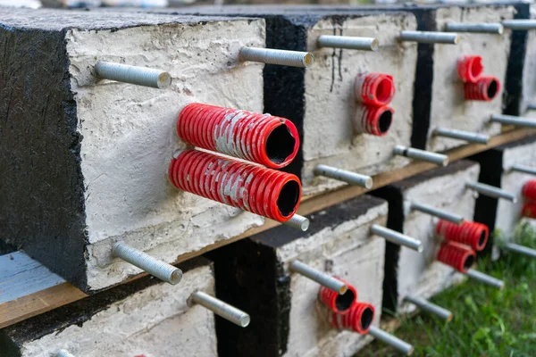 Concrete blocks with a red pipe inside. Laying of communications Corrupted pipes for electrical installation.