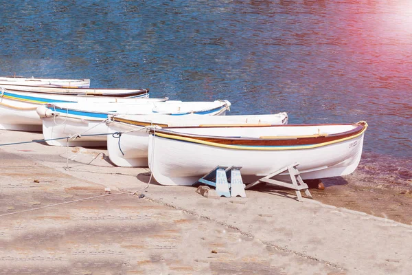 Old fishermans boats on white beach on warm sunset and copy spase. — Stock Photo, Image