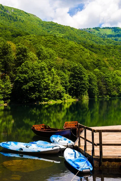 Barcos cerca de la orilla del lago, hermoso reflejo en el agua de los árboles. Lago Negro en el Parque Nacional Durmitor en Zabljak, Montenegro . — Foto de Stock