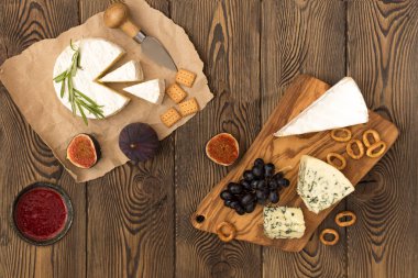 Otlar ve meyveler ahşap masa üzerinde peynir yemek tatma. Şarap ve romantik, peynir Şarküteri gıda. Üstten görünüm.