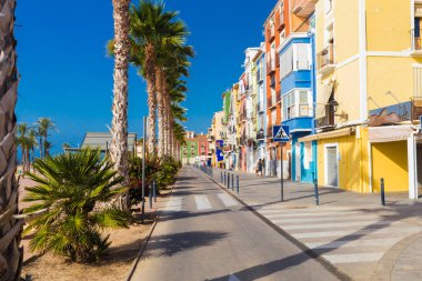 Colourful houses and palm trees on street in Villajoyosa, Spain. clipart