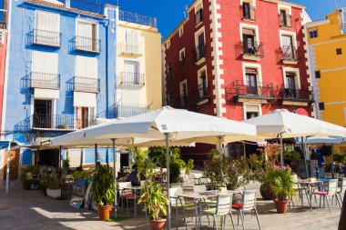 Cafe, renkli evler ve avuç içi Villajoyosa, İspanya güneşli bir sokakta