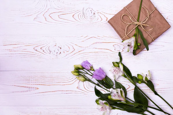 Flowers composition. Workspace with flowers, gift. Top view flat lay