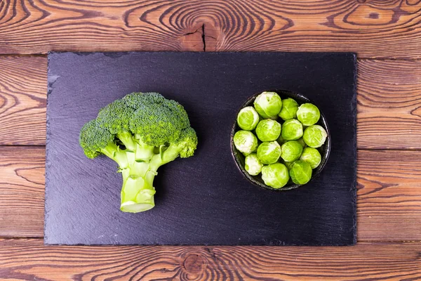 Ovanifrån Färsk Broccoli Brysselkål Svart Skiffer Och Ett Träbord Plats — Stockfoto