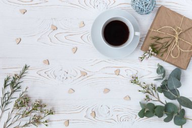 «Ana sayfa» kahve, görünümünü sarılı kraft kağıt, kalpler, beyaz tahta masaya çiçek hediye. Arka plan metin için boş alan ile. Düz yatıyordu