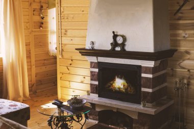 Kanepe ve sahte bir tablo tarafından şömineli rahat bir oturma odası. Sıcacık kış konsepti. Noel ve seyahat.