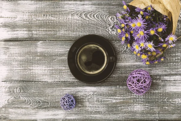 Tasse de café, fleur enveloppée dans du papier kraft sur une table grise d'en haut. Pose plate style pastel. Espace de copie pour le texte . — Photo