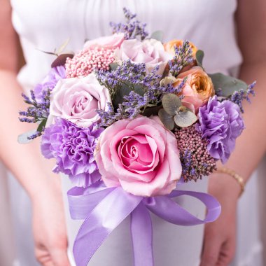 Beyaz elbiseli bir kız çiçek - kutlama, tatil ile yuvarlak bir kutu tutuyor.