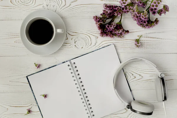 在白色木桌上可以看到日记或笔记本 咖啡和紫色花朵的顶视图 浪漫的平面设计 — 图库照片