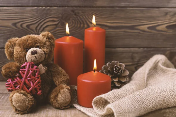 Valentine background. Red candles, a box in the form of a heart in rustic style . Selective focus.