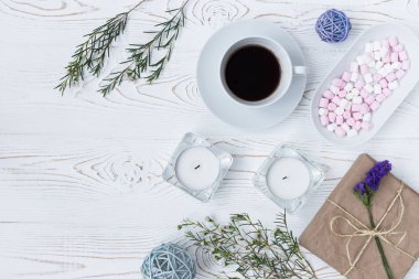 Beyaz ahşap masa üzerinde üstten görünüm kahve, hediyeler, hatmi, mumlar, çiçekler. Arka plan metin için boş alan ile. Düz yatıyordu.