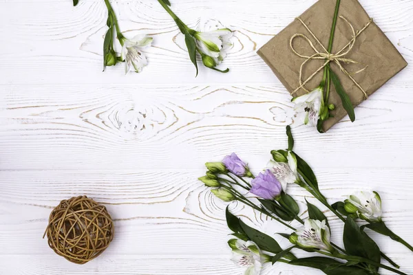 Una Confezione Regalo Avvolta Carta Kraft Fiori Spago Tavolo Bianco — Foto Stock