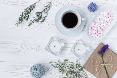 Beyaz ahşap masa üzerinde üstten görünüm kahve, hediyeler, hatmi, mumlar, çiçekler. Arka plan metin için boş alan ile. Düz yatıyordu.
