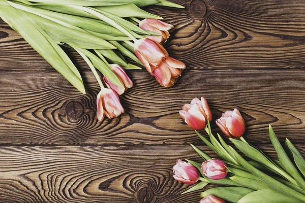 Tulipanes rojo-anaranjados sobre fondo de madera con espacio para texto en tono vintage. Puesta plana . —  Fotos de Stock