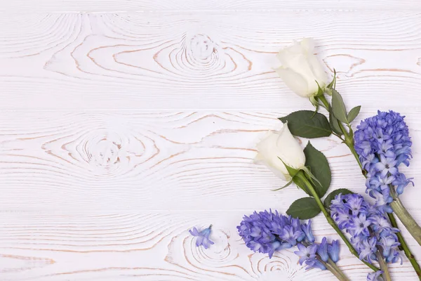 Vista dall'alto su fiori blu di giacinto e rose bianche su un tavolo di legno bianco con spazio per il testo — Foto Stock