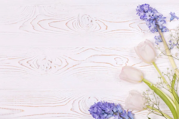 Vista dall'alto su fiori blu di giacinto e rose bianche su un tavolo di legno bianco con spazio per il testo — Foto Stock