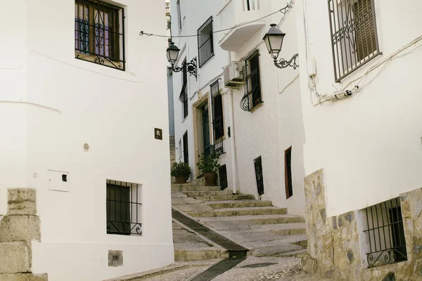 Hermosa calle estrecha en el casco antiguo con casas blancas y una carretera empedrada. Altea, España — Foto de Stock