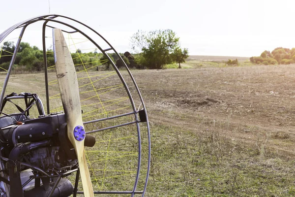 Close-up van een propeller met een motor-paraglider motor tegen de achtergrond van een veld. — Stockfoto