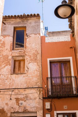 Peeling boya, çizik vintage alçı ve paslı demir sahte kafes ile bir balkon ile eski duvar.