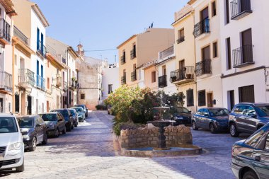 Finestrat, Alicante, Spain - February 23, 2019: Cozy little square with a fountain in the old town. clipart