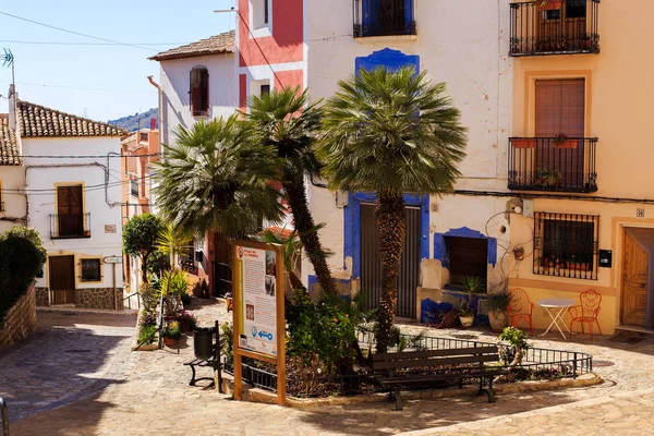 Finestrat, Alicante, España - 23 de febrero de 2019: Acogedor patio con palmeras y macetas en el casco antiguo con casas de colores con yeso desgastado . — Foto de Stock