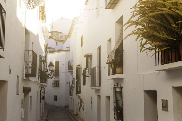 Altea, España - 19 de febrero de 2019: Hermosa calle estrecha en el casco antiguo con casas blancas y una carretera empedrada. Altea, España — Foto de Stock