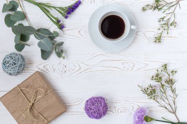 Çalışma alanı. Hediye, bir fincan kahve ve çiçek. Düz yatıyordu, üstten bak. Anneler günü.