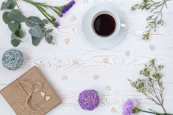 Espacio de trabajo. Regalo, taza de café y flores. Asiento plano, vista superior. Día de las madres . — Foto de Stock