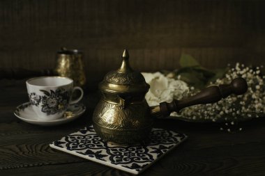 Kahve Türk ve ahşap bir masa üzerinde seramik standı üzerinde bir fincan kahve.