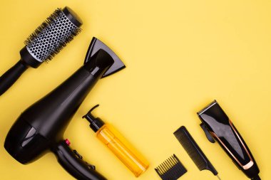 Saç kurutma, tarak, sprey, sarı arka planda makas, yazı için yer, düz yatış