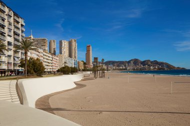 Benidorm, Alicante, İspanya - 27 Kasım 2019: İnsanlar Poniente 'nin fantastik modern gezinti alanında gökdelenler, palmiye ağaçları, kayalar ile yürüyorlar.
