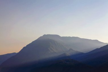 karanlık dağların üzerinde güneş ışınları